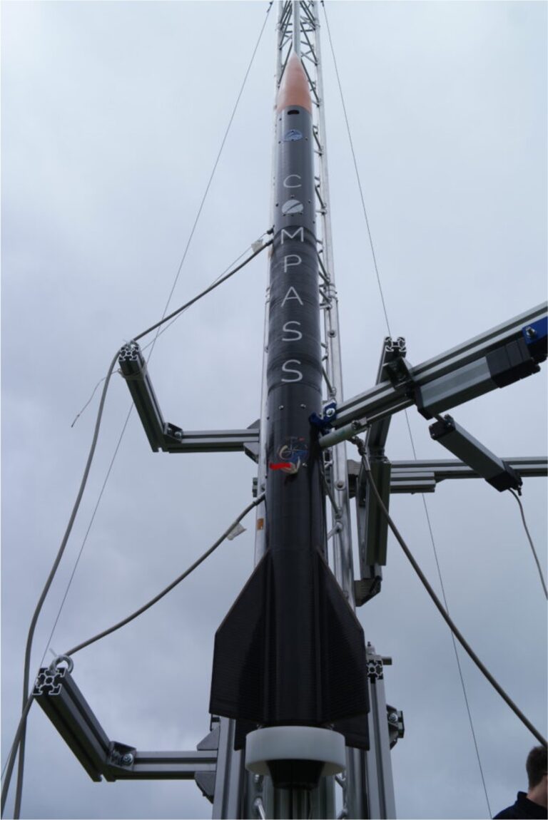 the compass rocket mounted on a launch rail, pointing upwards