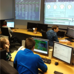 satellite control room with multiple people sitting in front of monitors displaying various data